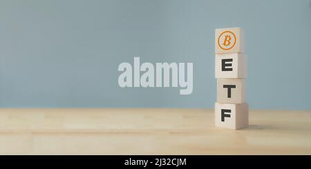 Fondo Exchange Traded Fund (ETF) e concetto di criptovaluta bitcoin. Entrare nel concetto di fondo di denaro digitale. Cubo verticale in legno con supporto per icone bitcoin Foto Stock