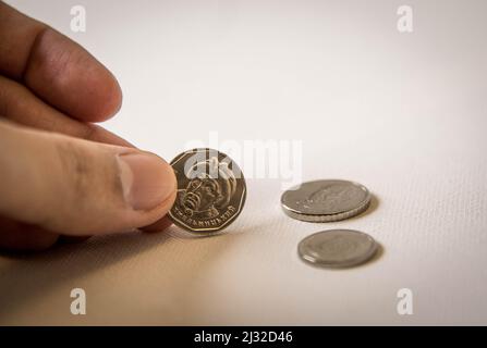 Foto di isolato con le dita di una mano che tiene le monete d'argento di Hryvnias ucraino con il volto di famosi scrittori Filosofi famosi. Foto Stock