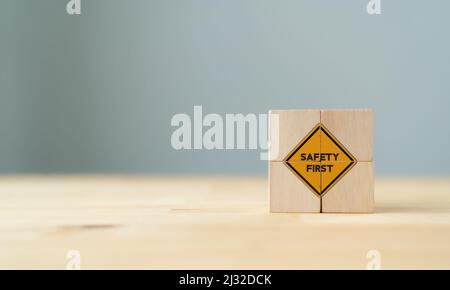 Simboli di sicurezza e primi segnali, sicurezza sul lavoro, attenzione rischi sul lavoro, sorveglianza dei pericoli, concetto di zero incidenti su cubi di legno con bac grigio bello Foto Stock