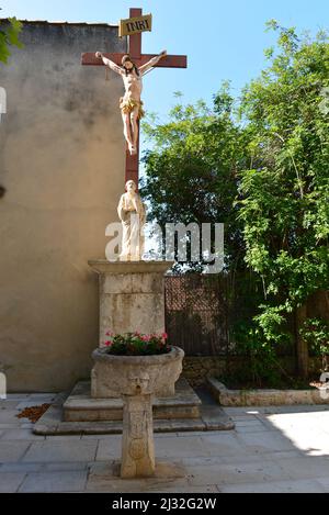 Crocifisso di fronte alla vecchia fontana in la Cadière d'Azur Foto Stock