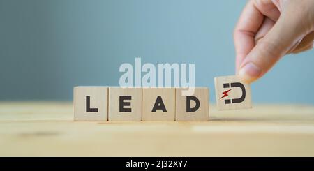 Concetto di generazione di lead. Guidare il cliente e la coltivazione. Strategia di marketing inbound. La mano tiene i cubi di legno con il magnete attrae le icone dei clienti standi Foto Stock