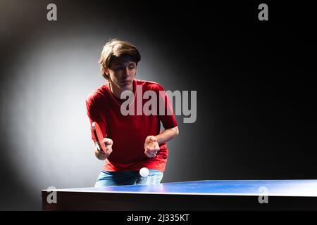 Teenager che gioca a ping pong ping pong. Attrezzatura, in movimento. Foto Stock