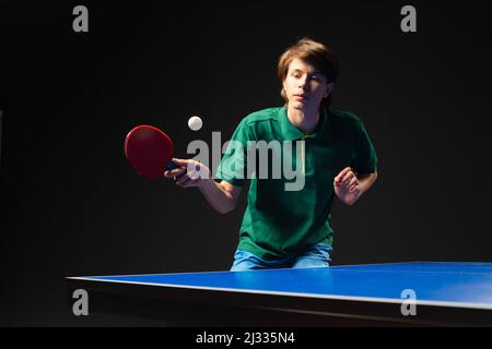 Teenager che gioca a ping pong ping pong. Attrezzatura, in movimento. Foto Stock