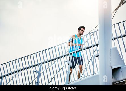 Alzando i suoi livelli di idoneità. Inquadratura a basso angolo di un bel giovane che si allenava in città. Foto Stock