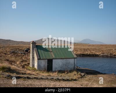 Una piccola capanna da pesca vicino ad un lago in Cashel, Connemara, Contea di Galway, Irlanda. Foto Stock