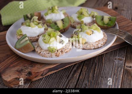 Sana proteina fitness prima colazione o snack con cracker di riso marrone. Sormontato da gracelo islandico e kiwi tritati Foto Stock