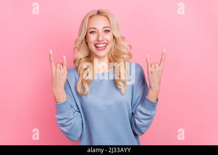 Foto di giovane bella ragazza mostra dita rock simbolo pesante punk swag isolato su sfondo di colore rosa Foto Stock