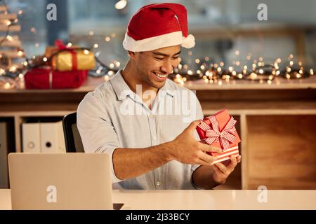 Questo è esattamente ciò che volevo. Scatto di un giovane uomo d'affari che festeggia il Natale al lavoro. Foto Stock