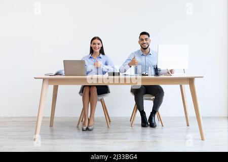 I colleghi che lavorano in ufficio sono felici di mostrare le miniature in alto Foto Stock