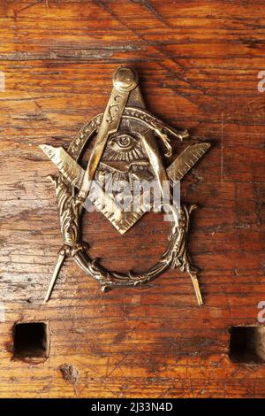 Un picchiettio in metallo su una porta in legno a forma di cartello Masonic Foto Stock