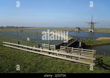 Diga e mulino a vento a Oost, Texel, Paesi Bassi Foto Stock