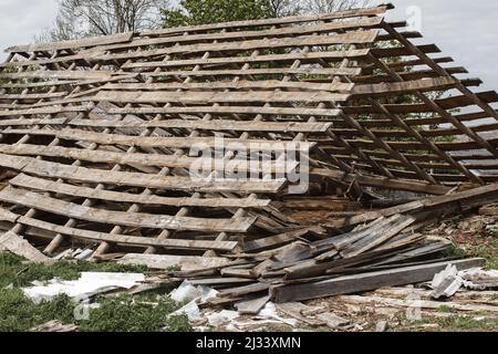 Vecchia casa in rovina con un tetto di bucata. Rimosso tegole tetto in ardesia su un tetto a falda su una casa derelitto Foto Stock