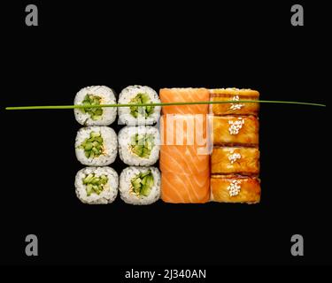 Sushi set roll salmone, anguilla, kappa maki. Isolato su sfondo nero Foto Stock