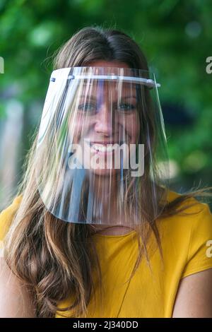 giovane donna che indossa una visiera protettiva Foto Stock