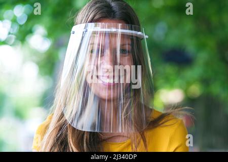 bella giovane donna che indossa una visiera protettiva Foto Stock