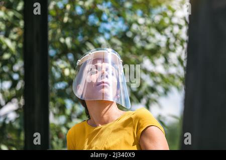 giovane donna che indossa una visiera protettiva durante l'epidemia di coronavirus Foto Stock