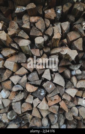 Primo piano stack di legna da ardere secca tronchi di legno di quercia, tagliato, spaccato e organizzato in un mucchio per giacenza di carburante invernale Foto Stock