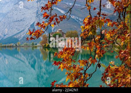 Lago Toblino con il castello in forma autunnale. È un piccolo lago alpino in provincia di Trento (Trentino-Alto Adige) ed è stato dichiarato Biotopo per le sue qualità naturalistiche. Posizione utilizzata per la produzione di pellicole. Italia Foto Stock