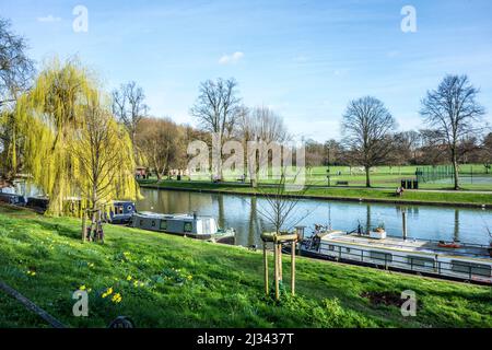 CAMBRIDGE, INGHILTERRA - MAR 13, 2017: Persone che camminano lungo il fiume Cam con barche a casa a Cambridge, Inghilterra. Vivere in casa barche è popolare a Cambridg Foto Stock