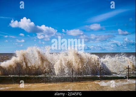 Onde che si infrangono sulla parete del mare in alta marea Foto Stock