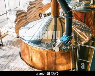 Attrezzature per birrifici. Produzione di birra. Vasche di stoccaggio rotonde cooper per la fermentazione e la maturazione della birra. Foto Stock