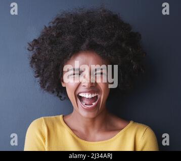 Im sulla ricerca della felicità. Studio girato di una giovane donna attraente in posa su uno sfondo grigio. Foto Stock