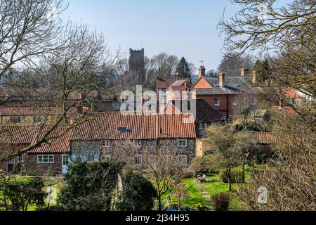 Vista sui tetti del villaggio di Norfolk di Castle Acre, con la torre della chiesa di St James in lontananza. Foto Stock