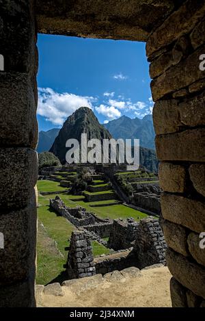 Machu Picchu attraverso l'antica porta in pietra che si affaccia su terrazze agricole utilizzate da inca come tempio e luogo santo. Foto Stock