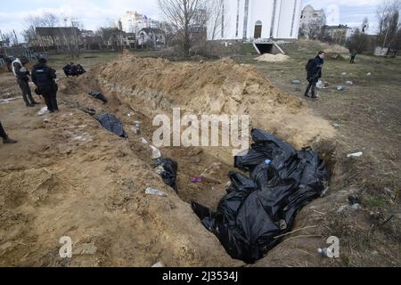 Bucha, Ucraina. 05th Apr 2022. NOTA DEI REDATTORI - una tomba di massa è visto dietro una chiesa nella città di Buca, a nord-ovest della capitale Ucraina Kiev, lunedì. Aprile 4, 2022. L'Ucraina e le nazioni occidentali hanno accusato le truppe russe di crimini di guerra dopo la scoperta delle tombe di massa e dei civili che apparentemente sono stati giustiziati nei pressi di Kiev. Un funzionario di salvataggio ha detto che 57 persone sono state trovate in una trincea scavata frettolosamente dietro una chiesa. Foto di Vladyslav Musienko/UPI Credit: UPI/Alamy Live News Foto Stock