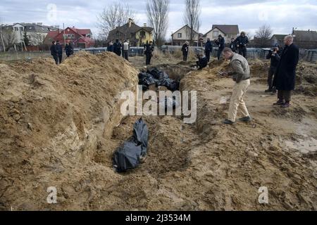 Bucha, Ucraina. 05th Apr 2022. NOTA PER GLI EDITOR - CONTENUTO GRAFICO. I funzionari guardano un sepolcro di massa nella città di Bucha, a nord-ovest della capitale Ucraina Kiev, lunedì. Aprile 4, 2022. L'Ucraina e le nazioni occidentali hanno accusato le truppe russe di crimini di guerra dopo la scoperta delle tombe di massa e dei civili che erano apparentemente eccitati nei pressi di Kyiv. Un funzionario di salvataggio ha detto che 57 persone sono state trovate in una trincea scavata frettolosamente dietro una chiesa. Foto di Vladyslav Musienko/UPI Credit: UPI/Alamy Live News Foto Stock