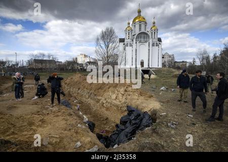 Bucha, Ucraina. 05th Apr 2022. NOTA DEI REDATTORI - una tomba di massa è visto dietro una chiesa nella città di Buca, a nord-ovest della capitale Ucraina Kiev, lunedì. Aprile 4, 2022. L'Ucraina e le nazioni occidentali hanno accusato le truppe russe di crimini di guerra dopo la scoperta delle tombe di massa e dei civili che apparentemente sono stati giustiziati nei pressi di Kiev. Un funzionario di salvataggio ha detto che 57 persone sono state trovate in una trincea scavata frettolosamente dietro una chiesa. Foto di Vladyslav Musienko/UPI Credit: UPI/Alamy Live News Foto Stock