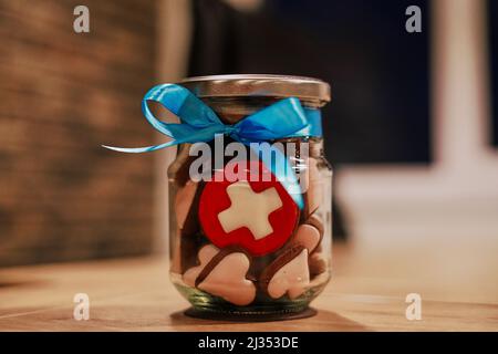 Vasetto con biscotti sotto forma di cuori e biscotti con bandiera svizzera Foto Stock