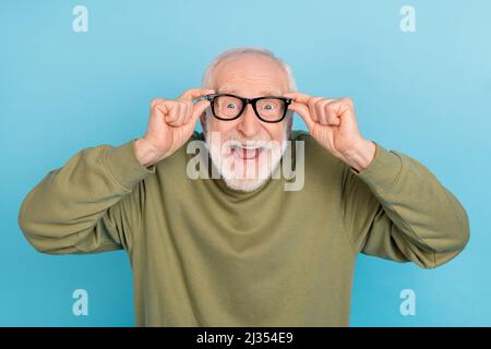 Ritratto di attraente pazzo allegro stupito uomo grigio-capelli geek toccare specifiche isolate su sfondo blu brillante Foto Stock