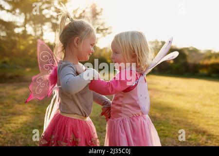 OH, che divertimento è essere bambini piccoli. Scatto ritagliato di due bambine che giocano insieme all'esterno. Foto Stock