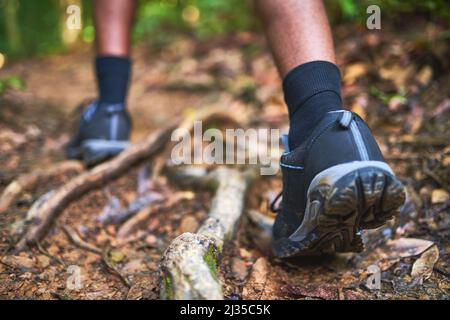 Trova nuovi percorsi da esplorare. Ripresa retroguidata di un escursionista non identificabile che cammina nella foresta. Foto Stock