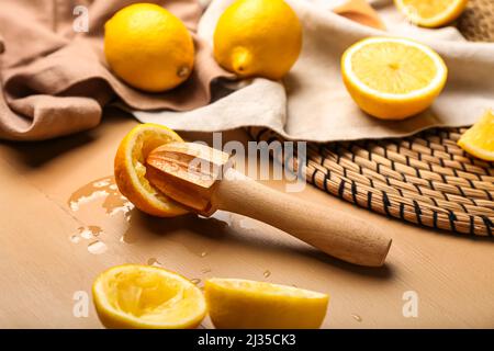 Tagliate i limoni e la centrifuga su sfondo di legno colorato Foto Stock