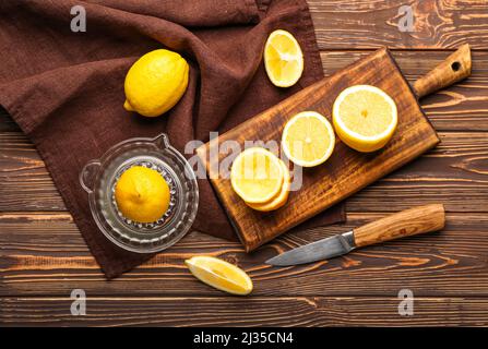 Composizione con centrifuga e limoni maturi su sfondo di legno Foto Stock