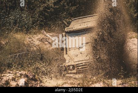 Fuoristrada camion sport tra montagne paesaggio. Fango è fuoristrada attraverso un'area di fango umido o argilla. Fango e spruzzi d'acqua fuori strada Foto Stock