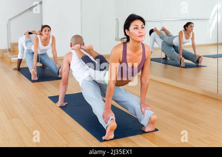 Lezioni di yoga per coppie nel moderno centro fitness Foto Stock