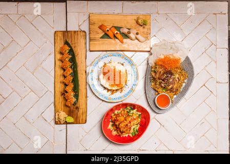 Menu sushi variato con nigiri, salmone norvegese, pesce farfalla, tonno rosso uramaki, riso bianco, alghe nori, wasabi, zenzero, torta di carote, gamberi fritti di ric Foto Stock