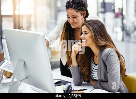 Va bene. Scatto corto di due giovani donne d'affari attraenti che lavorano ad una scrivania nel loro ufficio. Foto Stock