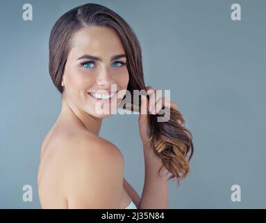 Shes bello e shes audace. Ritratto ritagliato di una bella giovane donna che si posa su uno sfondo grigio in studio. Foto Stock