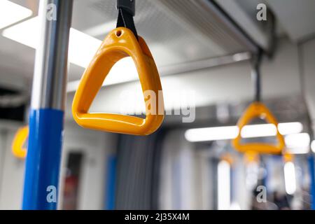 Trasporto pubblico in città. Metropolitana di Mosca. Corrimano gialli per il primo piano delle mani. Una metropolitana vuota ultimamente la sera. Ci sono poche persone in un Foto Stock