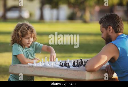 Padre e figlio che giocano a scacchi. Festa dei padri, famiglia d'amore, genitori, concetto d'infanzia. Giochi e attività per bambini. Ragazzo concentrato Foto Stock