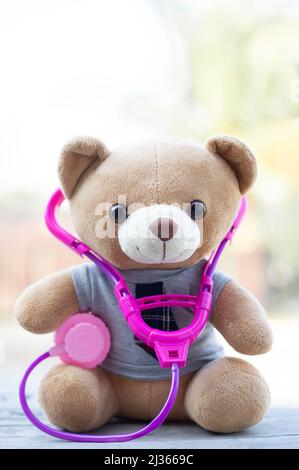 Foto verticale gli orsacchiotti marroni indossavano uno stetoscopio intorno al collo. Concetto di assistenza sanitaria. E spazio libero per il testo. Foto Stock