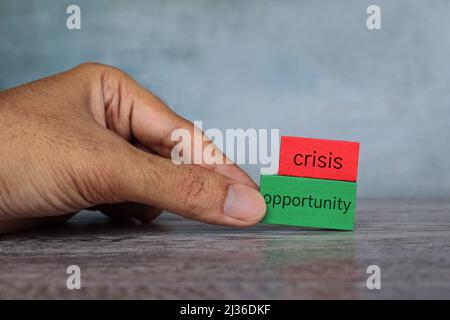 Mano scegliere cubo di legno con testo OPPORTUNITÀ oltre LA CRISI. Concetto aziendale. Foto Stock