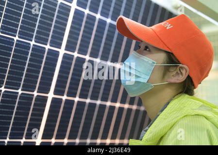 NANTONG, CINA - 6 APRILE 2022 - un dipendente controlla la qualità di un modulo fotovoltaico in un laboratorio intelligente solare a Nantong, Jiangsu Pr della Cina orientale Foto Stock