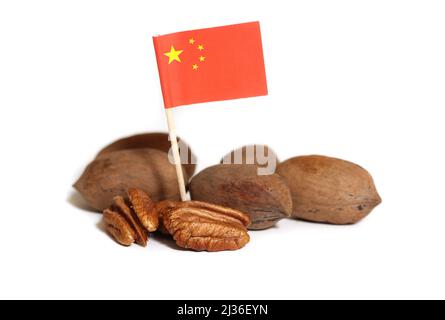 Pecan interi e sgusciati isolati su sfondo bianco con bandiera della Cina Foto Stock