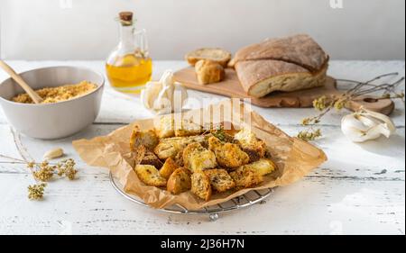 Crostini e pangrattati fatti in casa con spezie a base di pane raffermo, olio d'oliva, origano, pane raffermo, aglio. Sfondo bianco in legno. Zero conc. Rifiuti Foto Stock