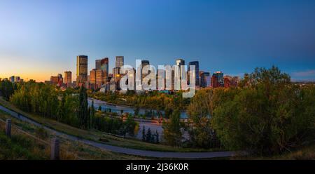 Tramonto sopra lo skyline della città di Calgary con il fiume Bow, Canada Foto Stock